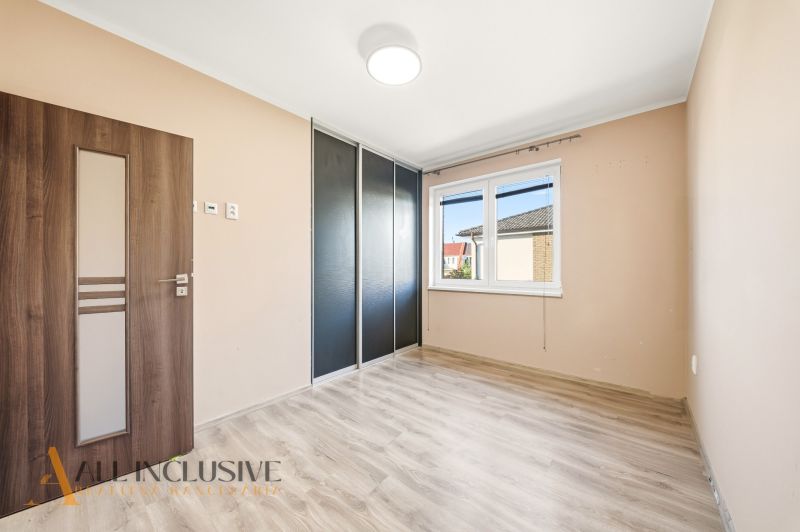 A room in a 3-room apartment with a wooden decor floor and a built-in wardrobe.