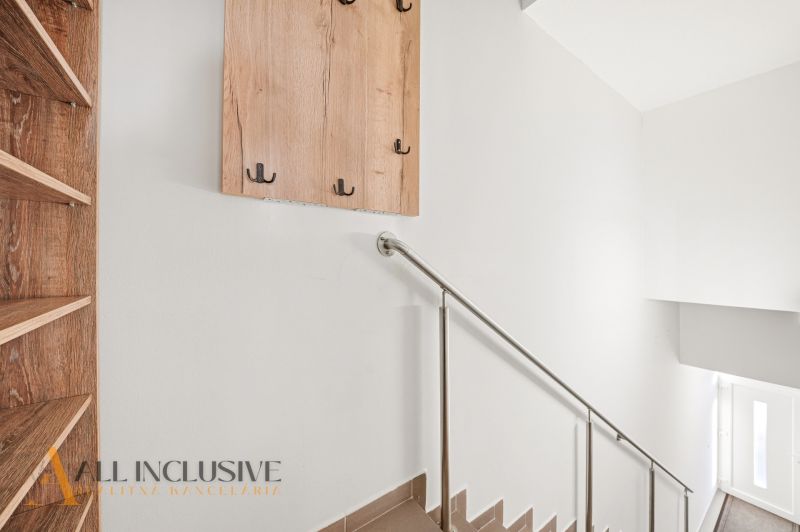 A staircase with a metal railing and wall hooks in a 3-room apartment.