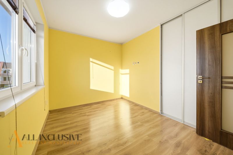 Yellow room in a 3-room apartment with a wooden decor floor and a built-in wardrobe.