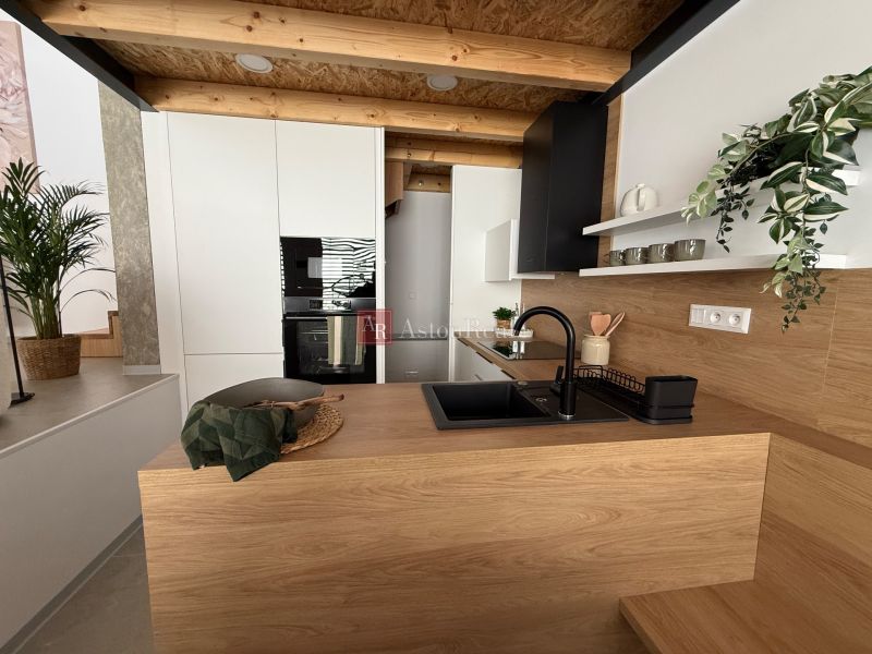 Modern kitchen in a family house with wood decor and a black sink.