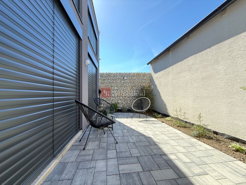The family house on Orviský kút in Piešťany has a terrace with tiles and garden chairs.