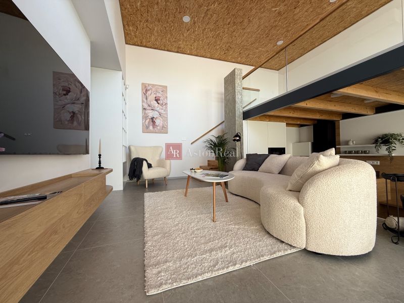 Living room in a family house with a comfortable sofa and decorative paintings on the wall.