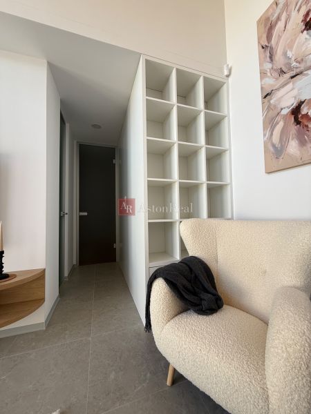 Armchair, storage shelf, and painting in the interior of a family house with floor decor.