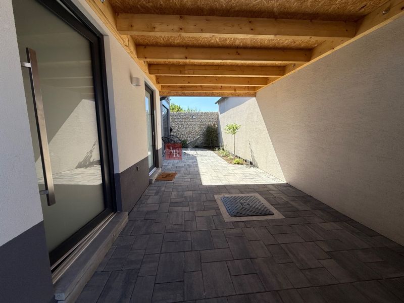 A family house in Piešťany on Orviský kút with a recessed terrace and paving.