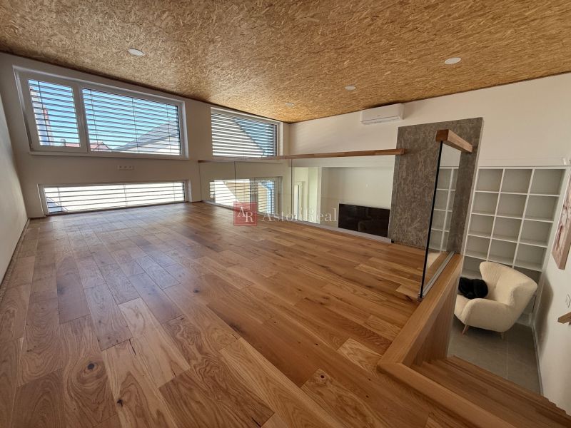 Interior of a family house with a wooden decor floor and large windows.
