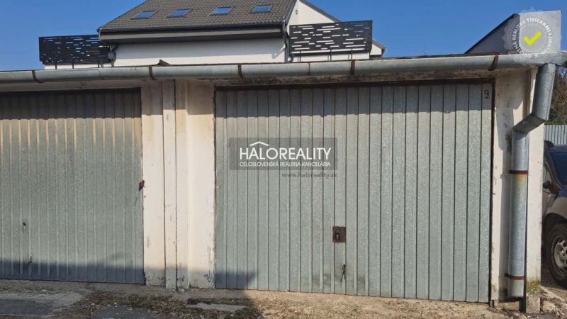 Garages in Senec with metal gates and a building roof.