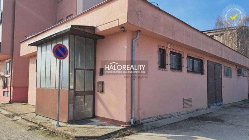 The exterior of an office building in Senec with a no parking sign and metal doors.