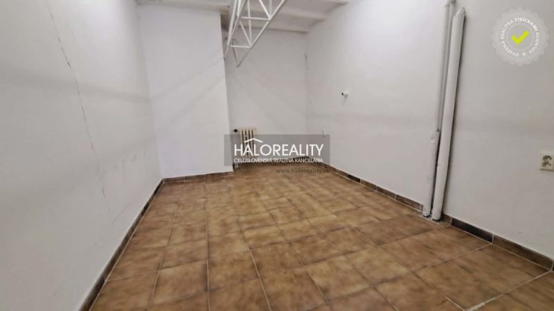 An office interior with white walls and brown tiles.