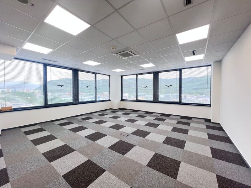 An empty office with carpet tiles and large windows, in the Offices.