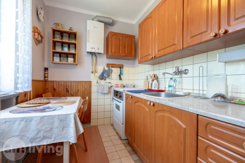 A kitchen in a 3-room apartment with wooden cabinets and a dining table.