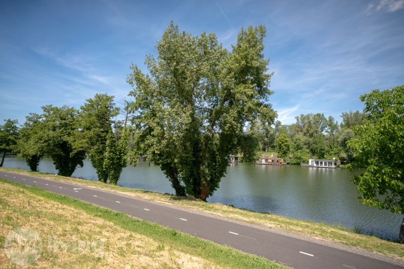 The path along the river with boats surrounded by greenery on Švermova Street in Trenčín.