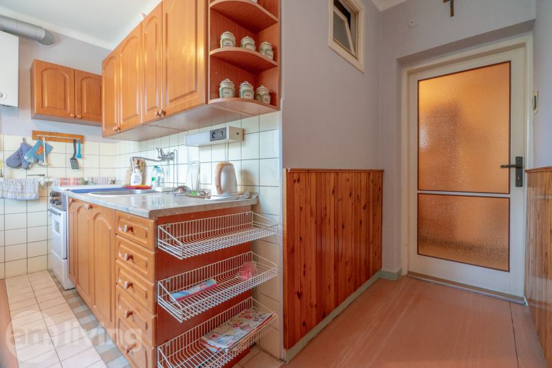 A kitchen with cabinets and basket shelves in a 3-room apartment, a floor with a wooden decor.