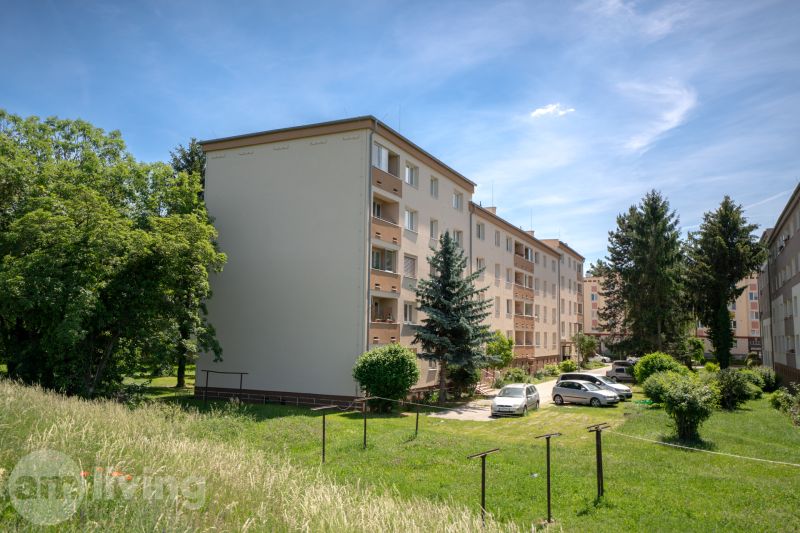 Apartment buildings on Švermova Street in Trenčín with surrounding greenery and parked cars.