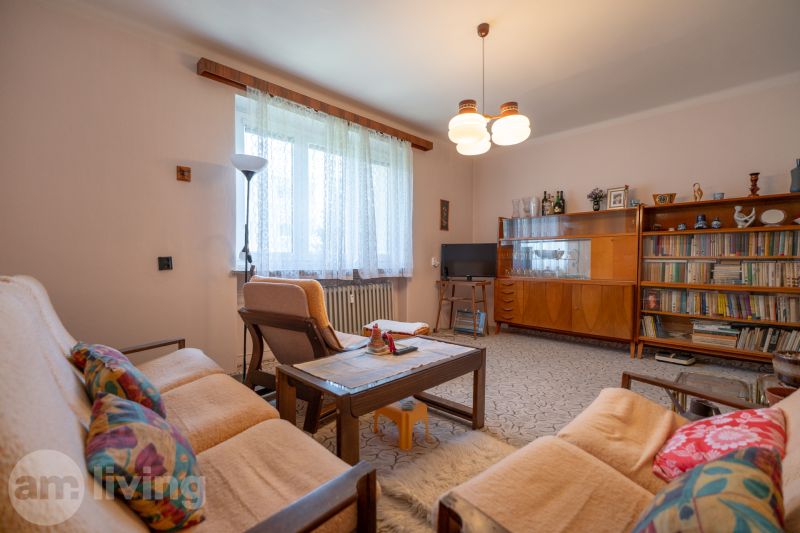 Living room in a 3-room apartment with retro furniture, a sofa, and a bookshelf.