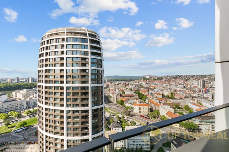 View from the balcony on Továrenská Street, with a panorama and a high-rise building.