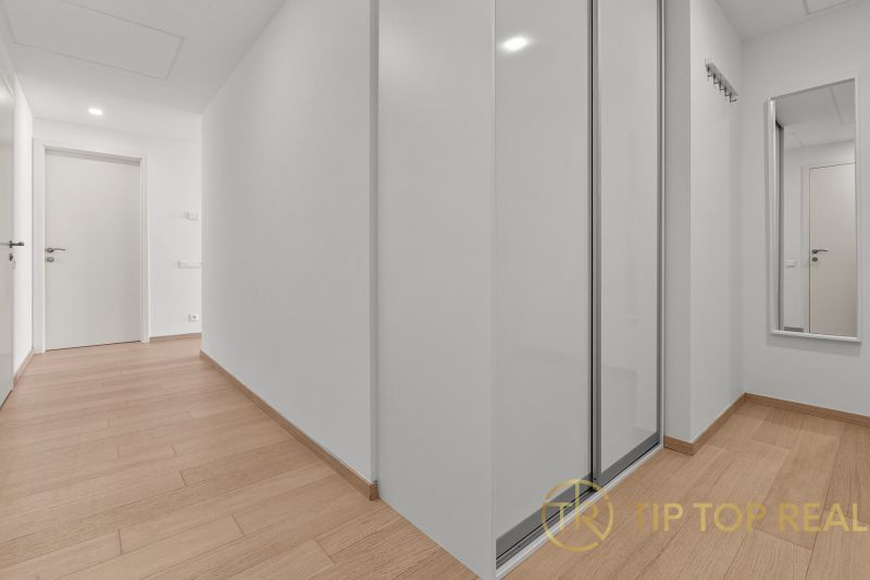 A spacious hallway with a built-in wardrobe in a 3-room apartment on Továrenská Street.