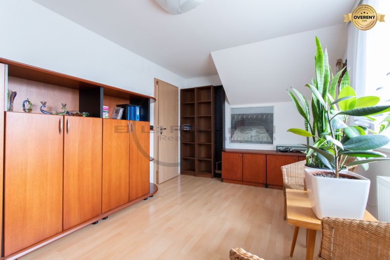 A room with wooden decor, cabinets, and plants in a family house.