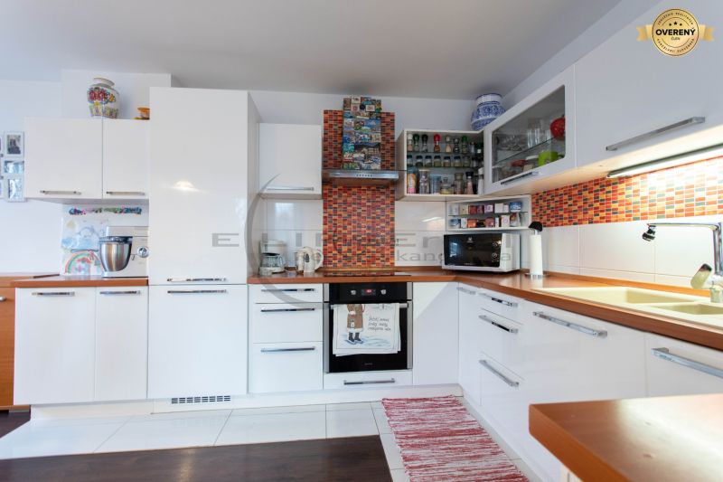 A kitchen in a family house with white cabinets and a wooden decor floor.