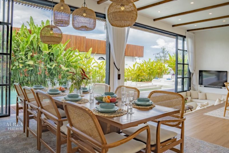 Dining room in the villa with a view of the garden and terrace, floor with wooden decor.