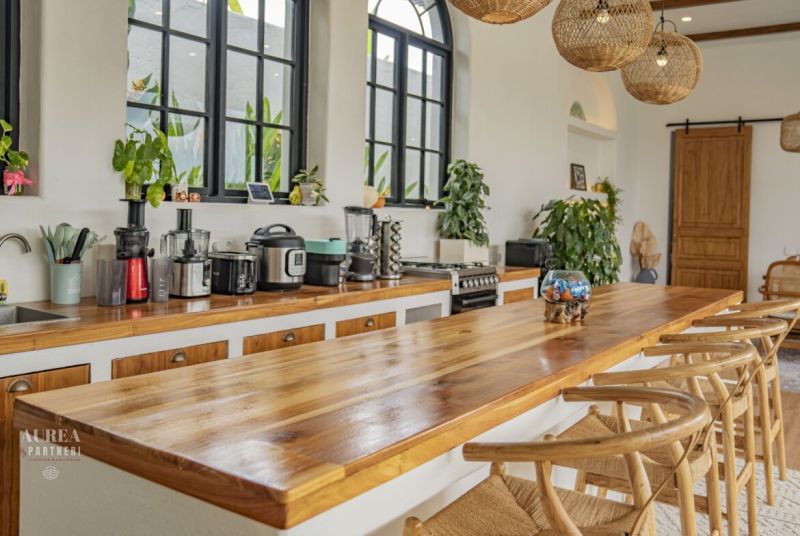 The villa's kitchen with an elegant wooden counter and window views of greenery.