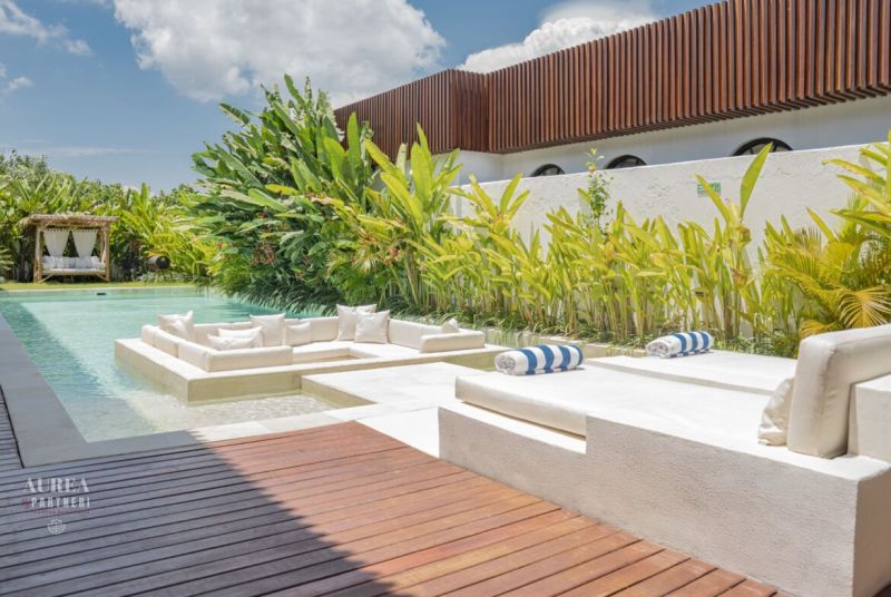 Luxury villa in Bali with a pool surrounded by greenery and a relaxation zone.