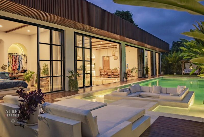 Villa in Bali with a pool and a terrace with wood-patterned flooring.