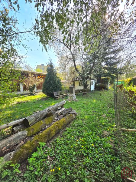 Gardens on 1st May Street in Košice - Krásna district, wooden logs and greenery.
