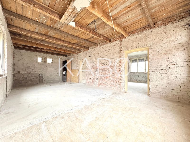 Interior of a family house with exposed bricks and a wooden ceiling.