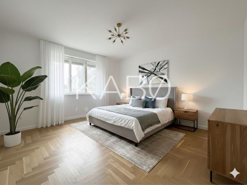 Bright bedroom in a family house with wood-patterned flooring and a houseplant.