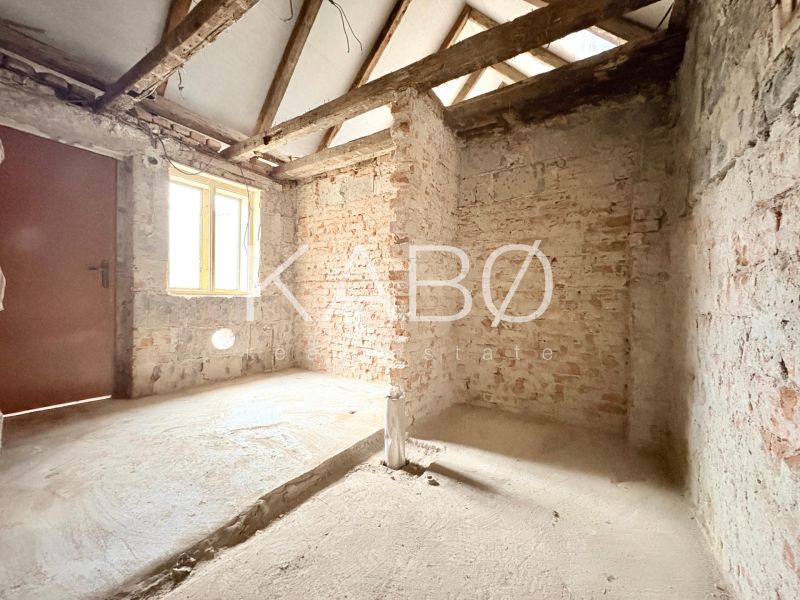 Interior of a family house with unplastered brick walls and raw concrete floor.