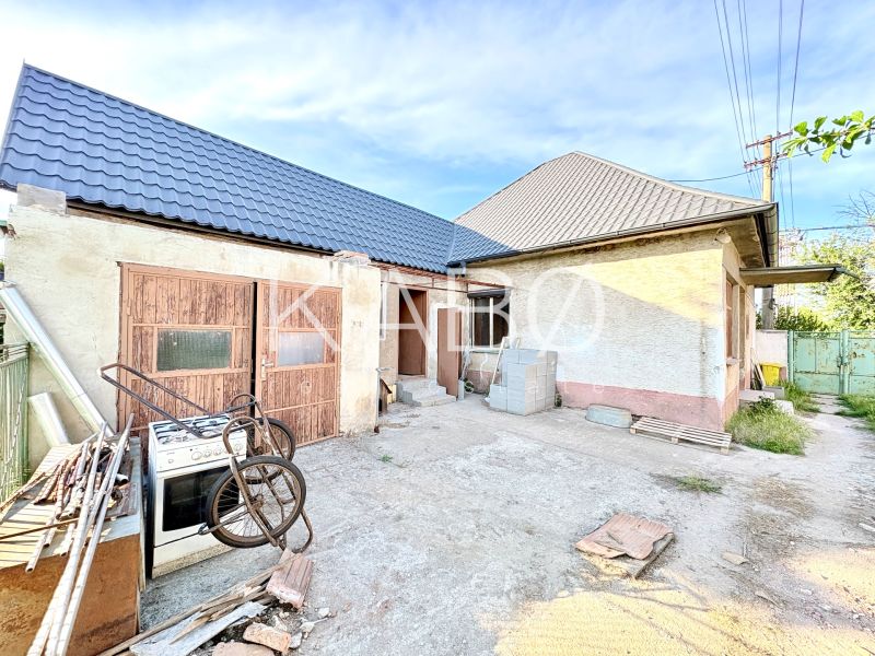A family house in Šoporňa with two roofs and an unkempt yard.