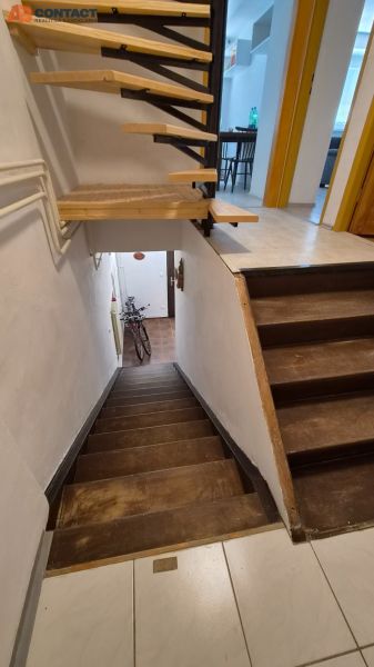 A staircase in a 2-room apartment with a wooden decor and a bicycle at the entrance.