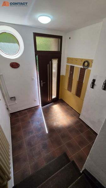 An entrance hall with tiled flooring and a decorative round window in a 2-room apartment.