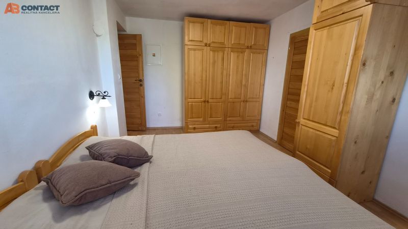 Bedroom in a 2-room apartment with wooden wardrobes, a bed, and a floor with a wooden decor.