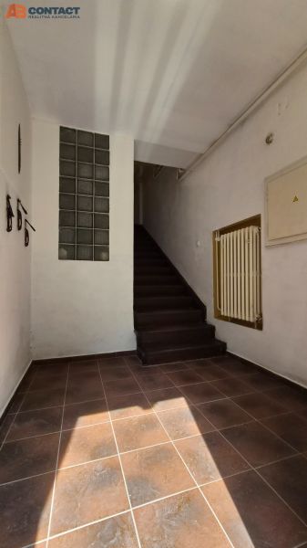 Hallway of a staircase in a 2-room apartment with ceramic tiles and stairs.