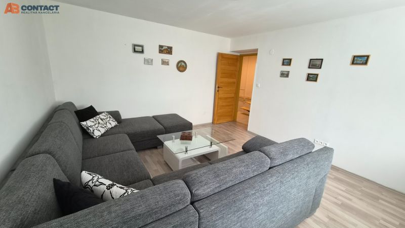 Living room in a two-room apartment with a comfortable sofa and a glass table.
