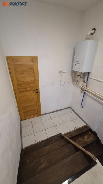 A staircase with wooden steps and a gas boiler in a 2-room apartment.