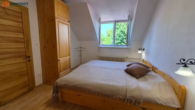 A bedroom with wooden furniture and a floor with a wooden decor in a 2-room apartment.