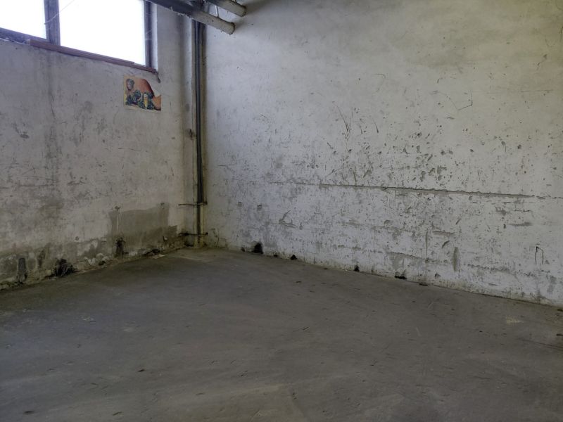 Industrial interior with worn walls and gray flooring, warehouses and halls.