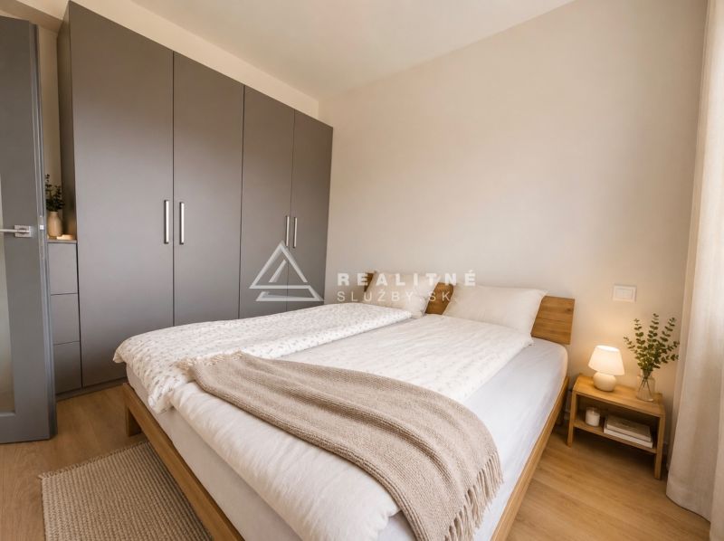 A bedroom in a two-room apartment with a wooden decor floor, a large wardrobe, and a nightstand.