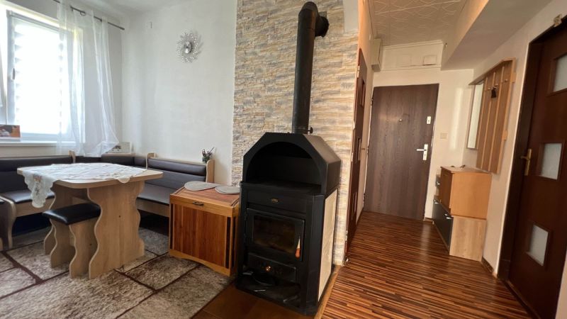 Interior of a 3-room apartment with a fireplace stove and flooring with a wood decor.