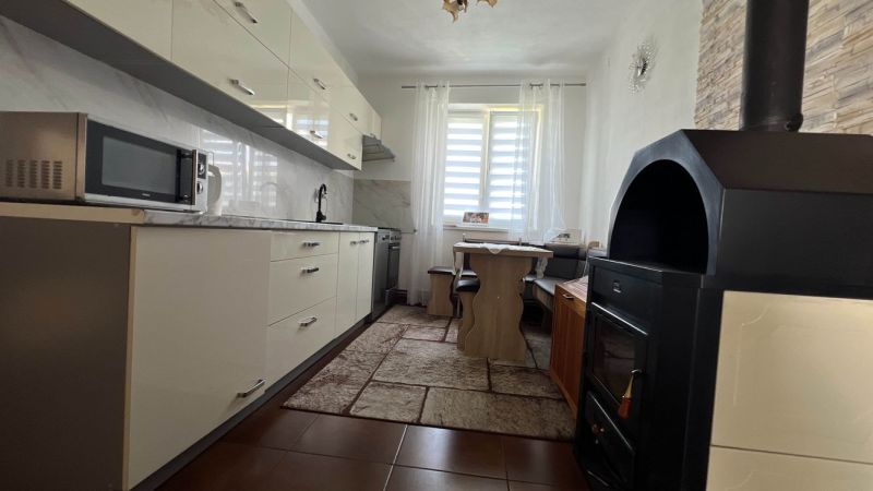 A kitchen in a 3-room apartment with a white unit and a microwave.