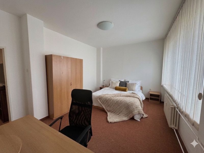Bedroom in a 3-room apartment with a desk and a large window.