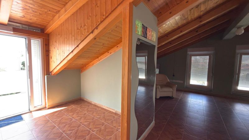 Interior of a family house with a wooden decor floor and a sloped ceiling.
