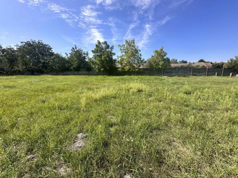 Peaceful greenery designated for residential plots in Vydrany, surrounded by trees and a fence.