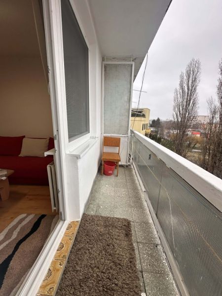 Balcony of a holiday apartment with a view of trees in Dunajská Streda.