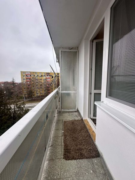 A balcony with a carpet mat in the Recreational Apartment Dunajská Streda, view of the housing estate.