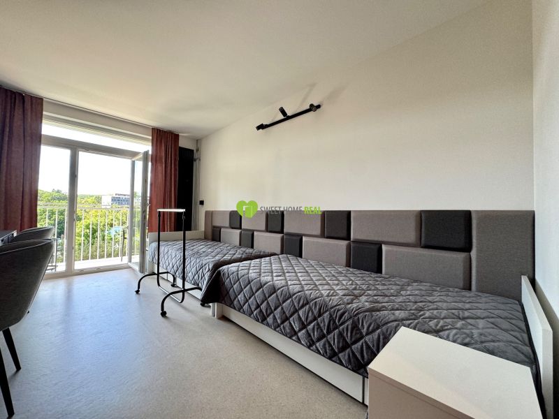 Studio apartment with a bed, armchairs, and large windows, in Košice on Kysucká.
