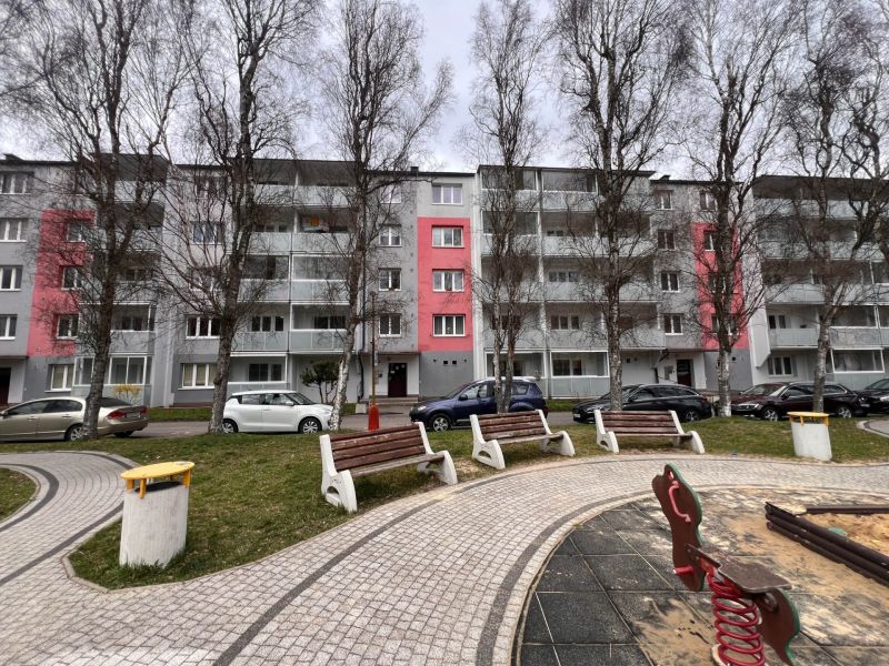 An apartment building in Ružomberok with trees and parking spaces in front of the two-room apartments.