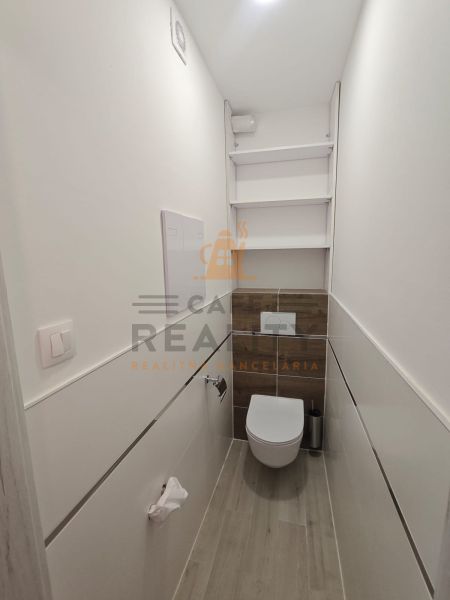 Cozy bathroom with wood-patterned flooring in a studio apartment.